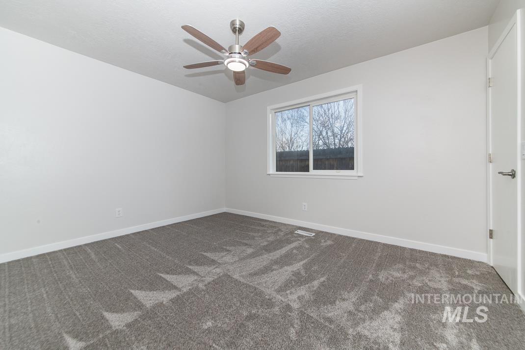480 Easy Street Kuna, ID 83634 - Photo 15 of 39 Spare room with dark colored carpet and a ceiling fan