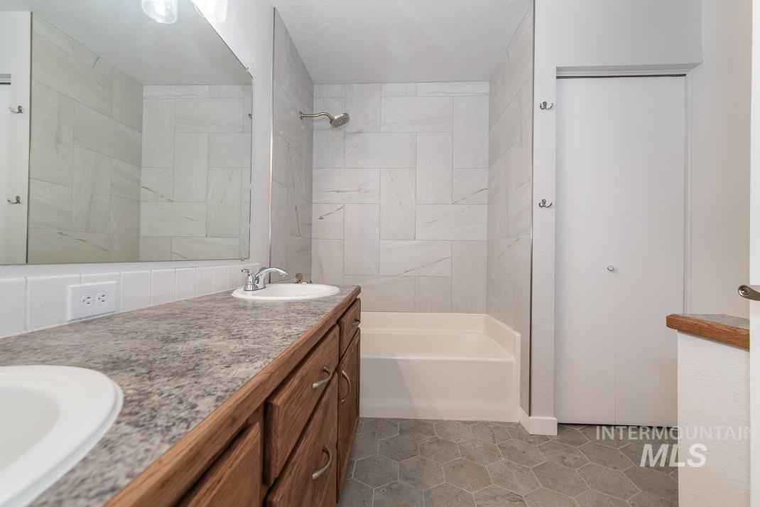 480 Easy Street Kuna, ID 83634 - Photo 21 of 39 Full bath featuring double vanity, shower / washtub combination, and light tile patterned flooring