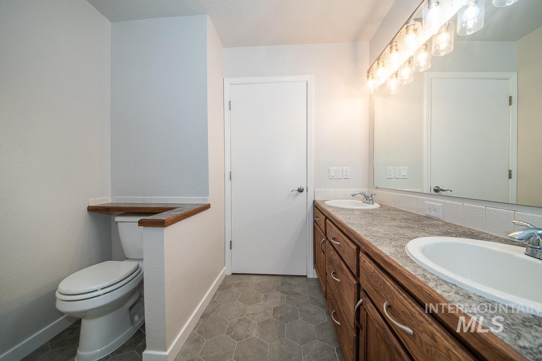480 Easy Street Kuna, ID 83634 - Photo 22 of 39 Full bath featuring double vanity and dark tile patterned flooring
