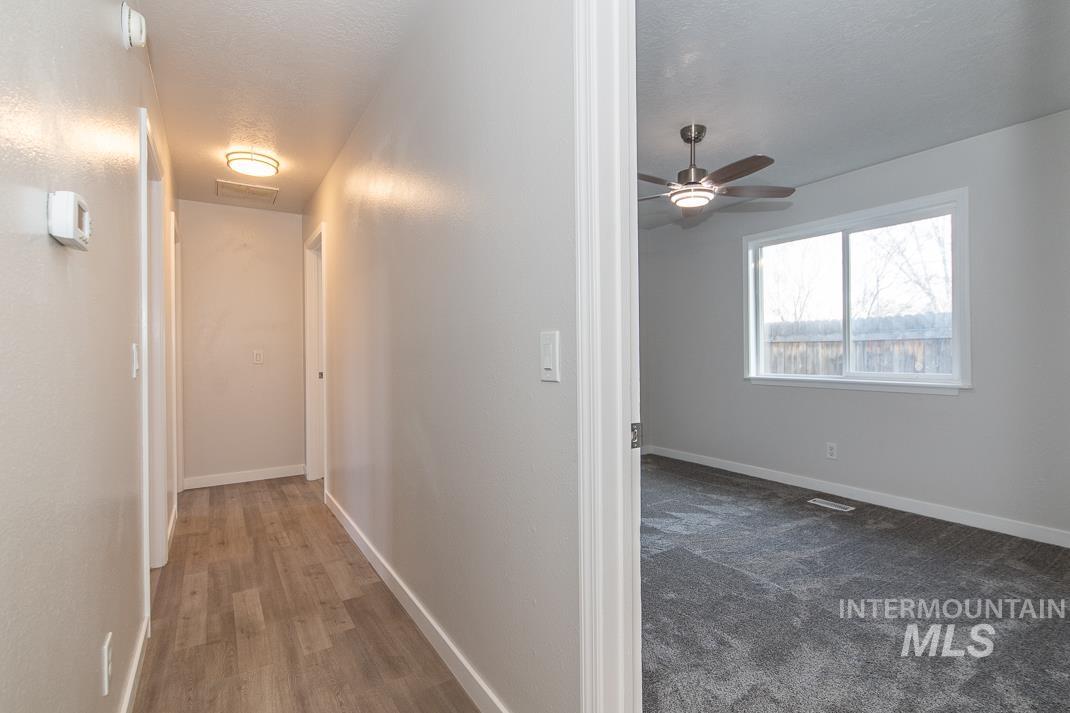 480 Easy Street Kuna, ID 83634 - Photo 23 of 39 Corridor with dark wood-style flooring and a textured ceiling