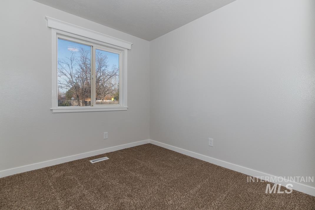 480 Easy Street Kuna, ID 83634 - Photo 9 of 39 Empty room featuring baseboards and dark carpet