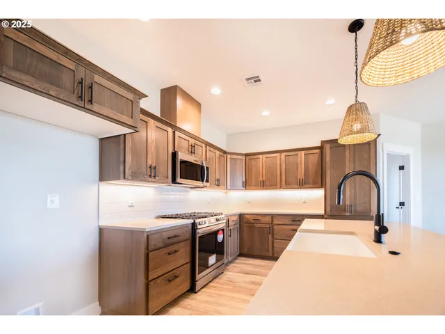 a kitchen with kitchen island a counter top a stove a sink and a refrigerator