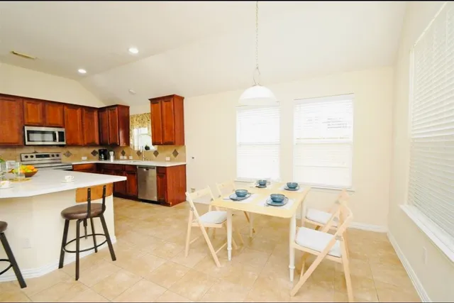 a kitchen with a table chairs microwave and cabinets