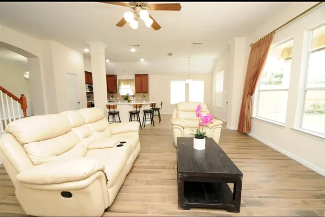 a living room with stainless steel appliances kitchen island furniture and a large window