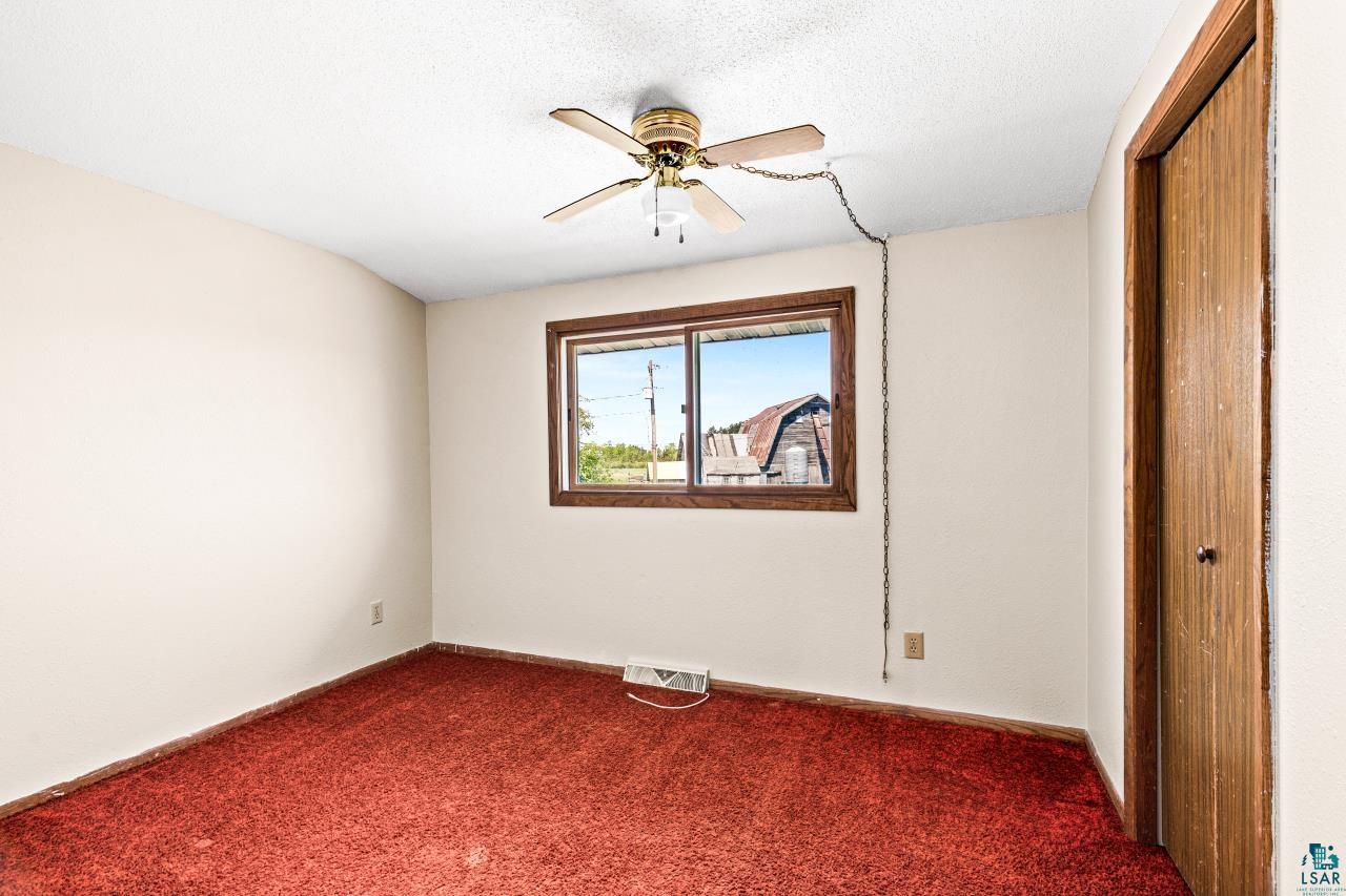 6606 Metso Road Kettle River, MN 55757 - Photo 27 of 84 Room featuring reddish-orange carpeting, light-toned walls, and a window with wood-finish trim