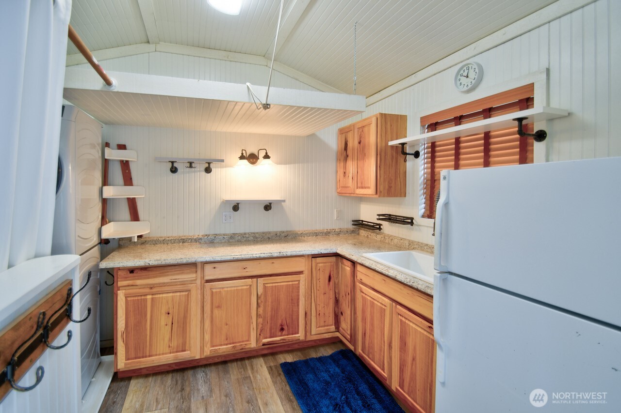 1546 Reservation Road Southeast, Unit 249 Olympia, WA 98513 - Photo 16 of 37 a kitchen with a sink a stove cabinets and wooden floor