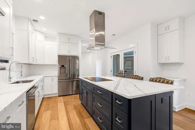 a large room with kitchen view and a wooden floor