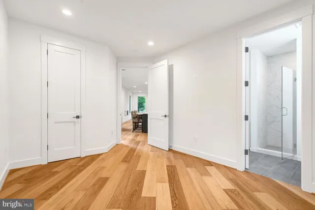a view of empty room with window and wooden floor