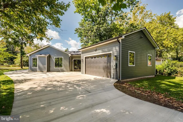 a front view of a house with a garden and yard