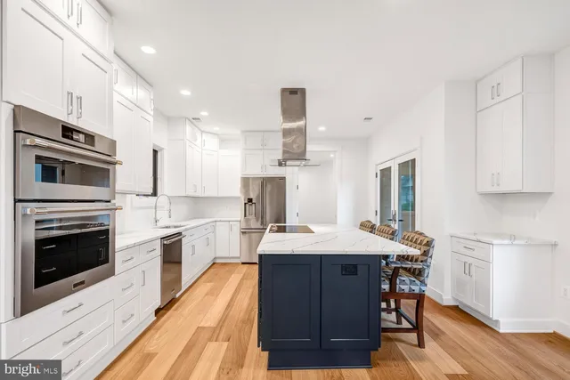 a kitchen with stainless steel appliances kitchen island granite countertop a stove a sink and a refrigerator