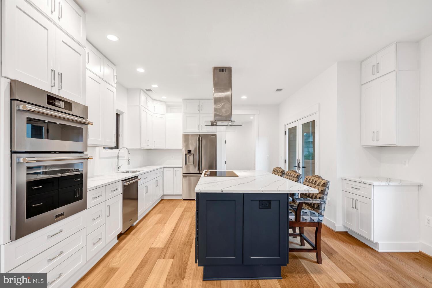 13711 Joyce Road Woodbridge, VA 22191 - Photo 7 of 54 a kitchen with stainless steel appliances kitchen island granite countertop a stove top oven a sink dishwasher and white cabinets with wooden floor