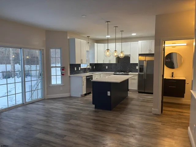 a large kitchen with stainless steel appliances granite countertop a stove and a sink