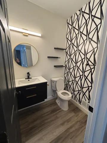a bathroom with a toilet a sink and mirror