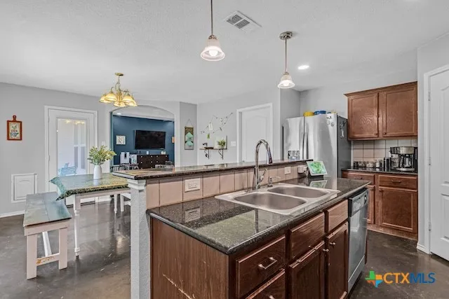 a kitchen that has a sink a stove and chairs