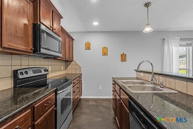 a kitchen with stainless steel appliances granite countertop a sink stove and cabinets