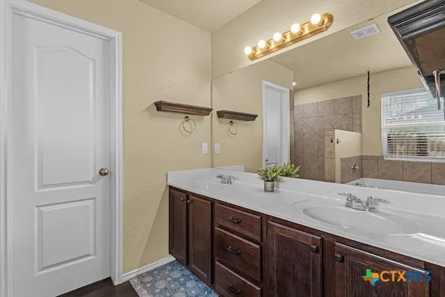 a bathroom with a double vanity sink and a mirror
