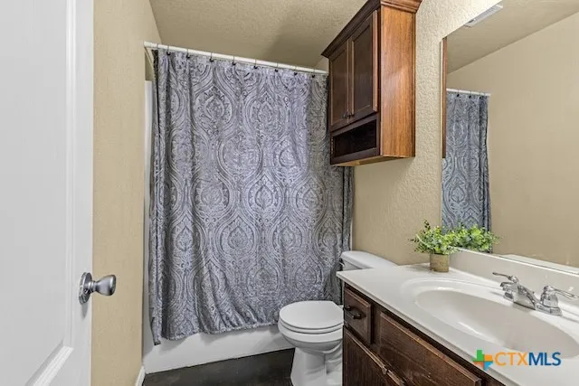a bathroom with a granite countertop sink toilet and a mirror