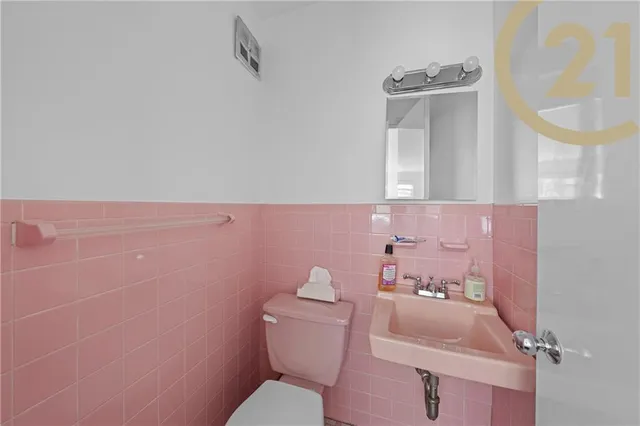 a bathroom with a toilet sink and mirror