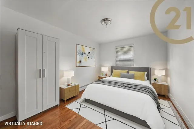 a bedroom with a bed and a potted plant on the dresser