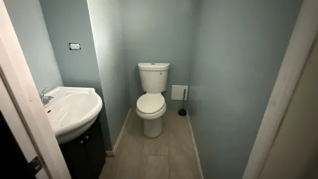 a white toilet sitting next to a white sink and vanity