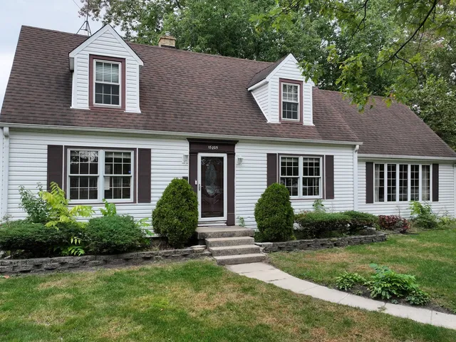 a front view of a house with a yard and plants