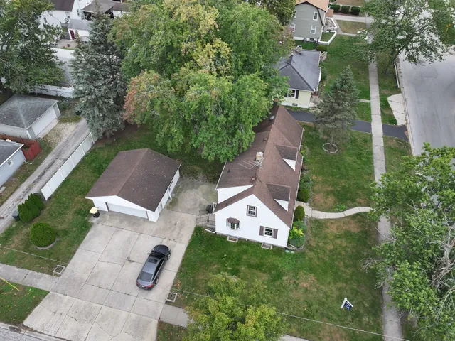 an aerial view of residential houses with outdoor space and trees