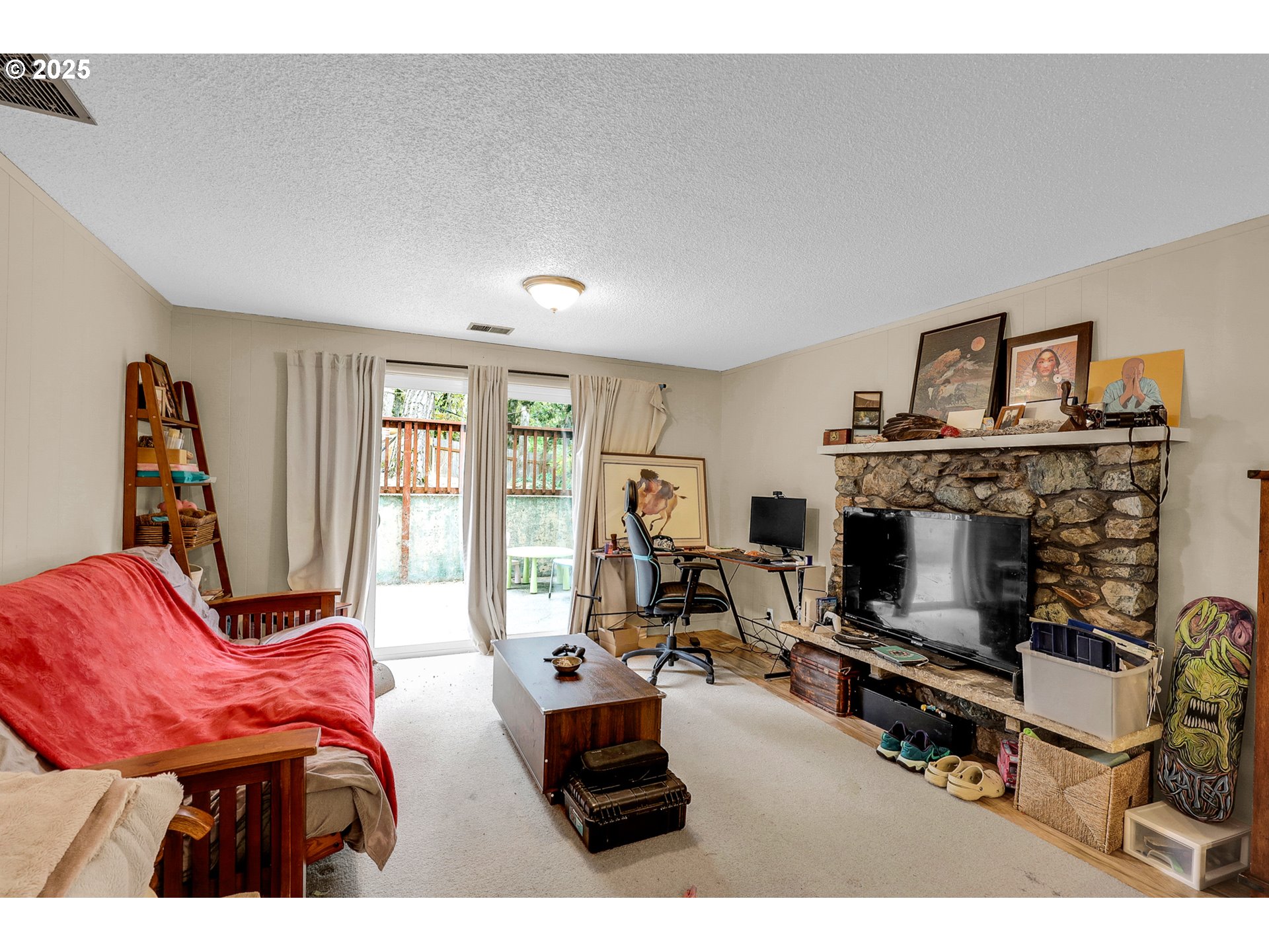 910 East 43rd Avenue Eugene, OR 97405 - Photo 32 of 47 a living room with furniture a flat screen tv and a fireplace