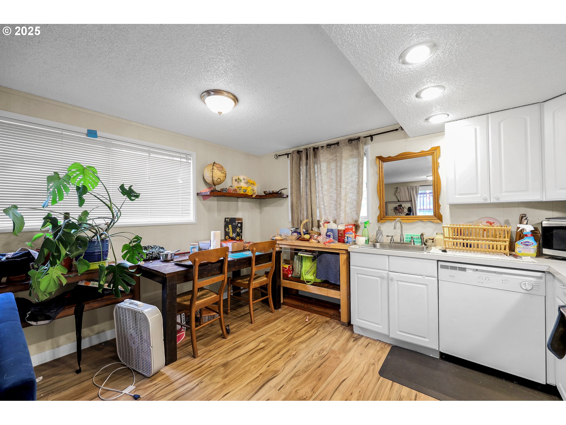 910 East 43rd Avenue Eugene, OR 97405 - Photo 36 of 47 a kitchen with stainless steel appliances granite countertop a sink dishwasher and white cabinets with wooden floor