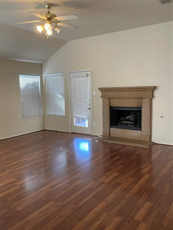 8271 Horse Whisper Lane Fort Worth, TX 76131 - Photo 3 of 12 an empty room with wooden floor fireplace and windows