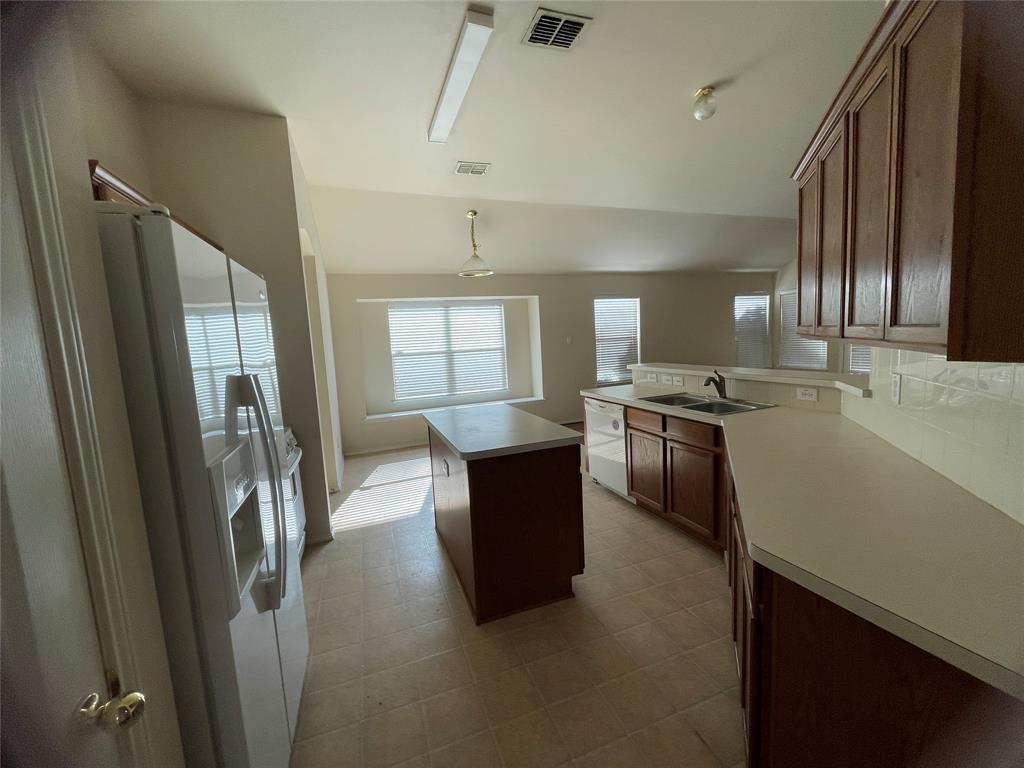 8271 Horse Whisper Lane Fort Worth, TX 76131 - Photo 5 of 12 a kitchen with stainless steel appliances granite countertop a refrigerator a stove and a sink