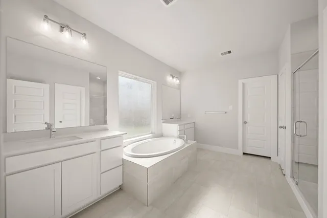 a bathroom with a sink double vanity granite tub shower and a mirror