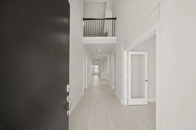 a view of a hallway with wooden floor and staircase