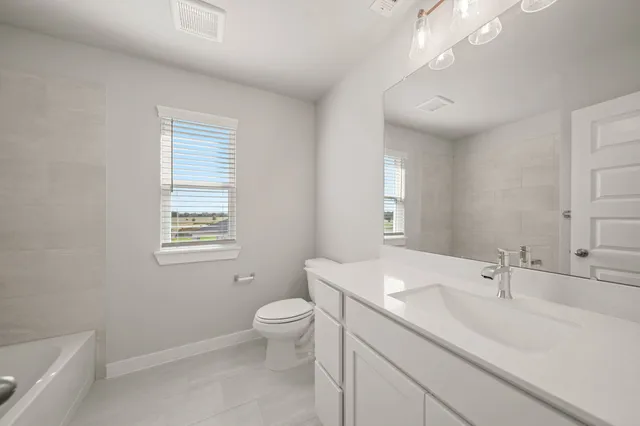 a bathroom with a granite countertop sink a toilet and a bathtub
