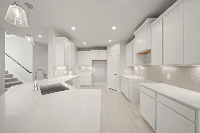 a kitchen with stainless steel appliances cabinets a sink and a center island