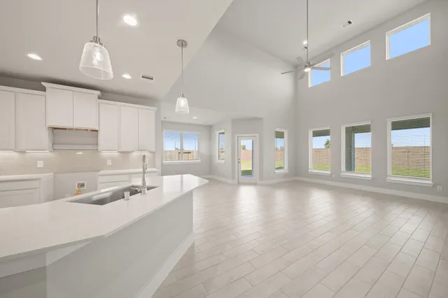 a large white kitchen with a large window a sink and stainless steel appliances