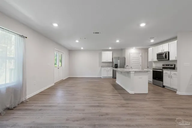 a view of kitchen with wooden floor and electronic appliances