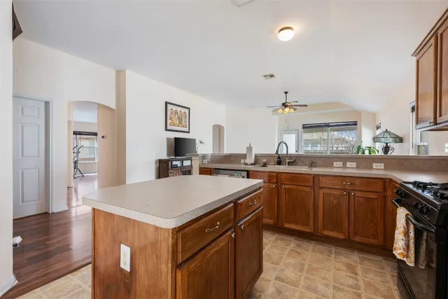a kitchen with stainless steel appliances kitchen island granite countertop a refrigerator and a stove