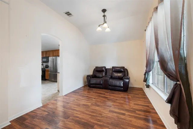a living room with furniture and a wooden floor