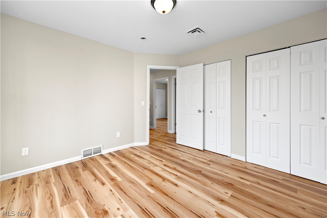 12452 Island Road Grafton, OH 44044 - Photo 19 of 39 Unfurnished bedroom with multiple closets and light wood finished floors