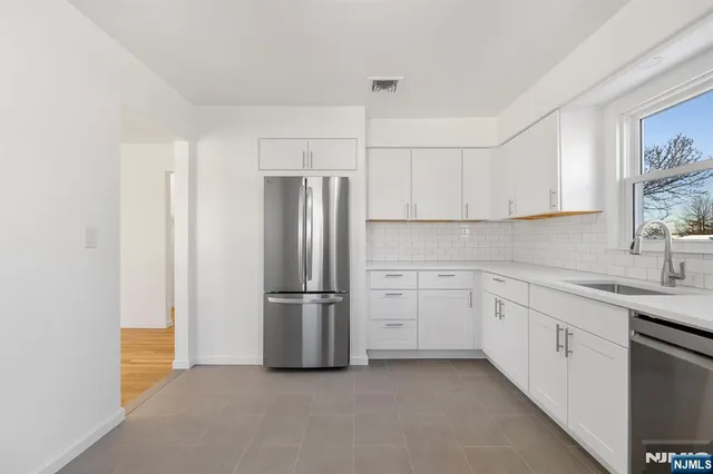 a kitchen with a refrigerator sink and cabinets