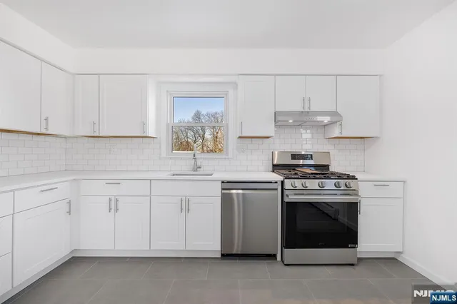 a kitchen with cabinets stainless steel appliances and a sink