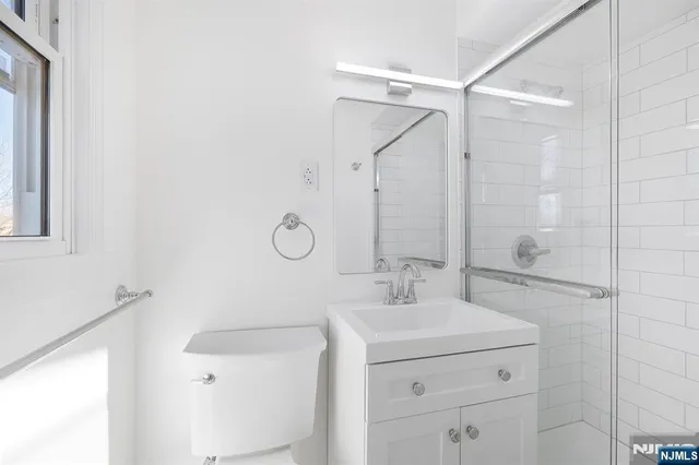 a bathroom with a sink mirror vanity and shower