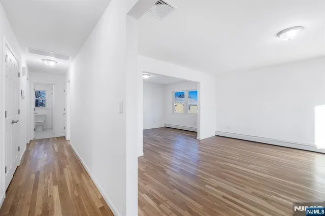 a view of an empty room and wooden floor