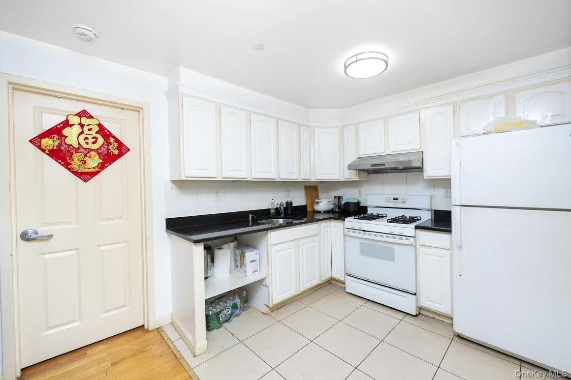 43-17 Union Street, Unit 2B Queens, NY 11355 - Photo 6 of 7 a kitchen with stainless steel appliances granite countertop a stove a sink and a refrigerator