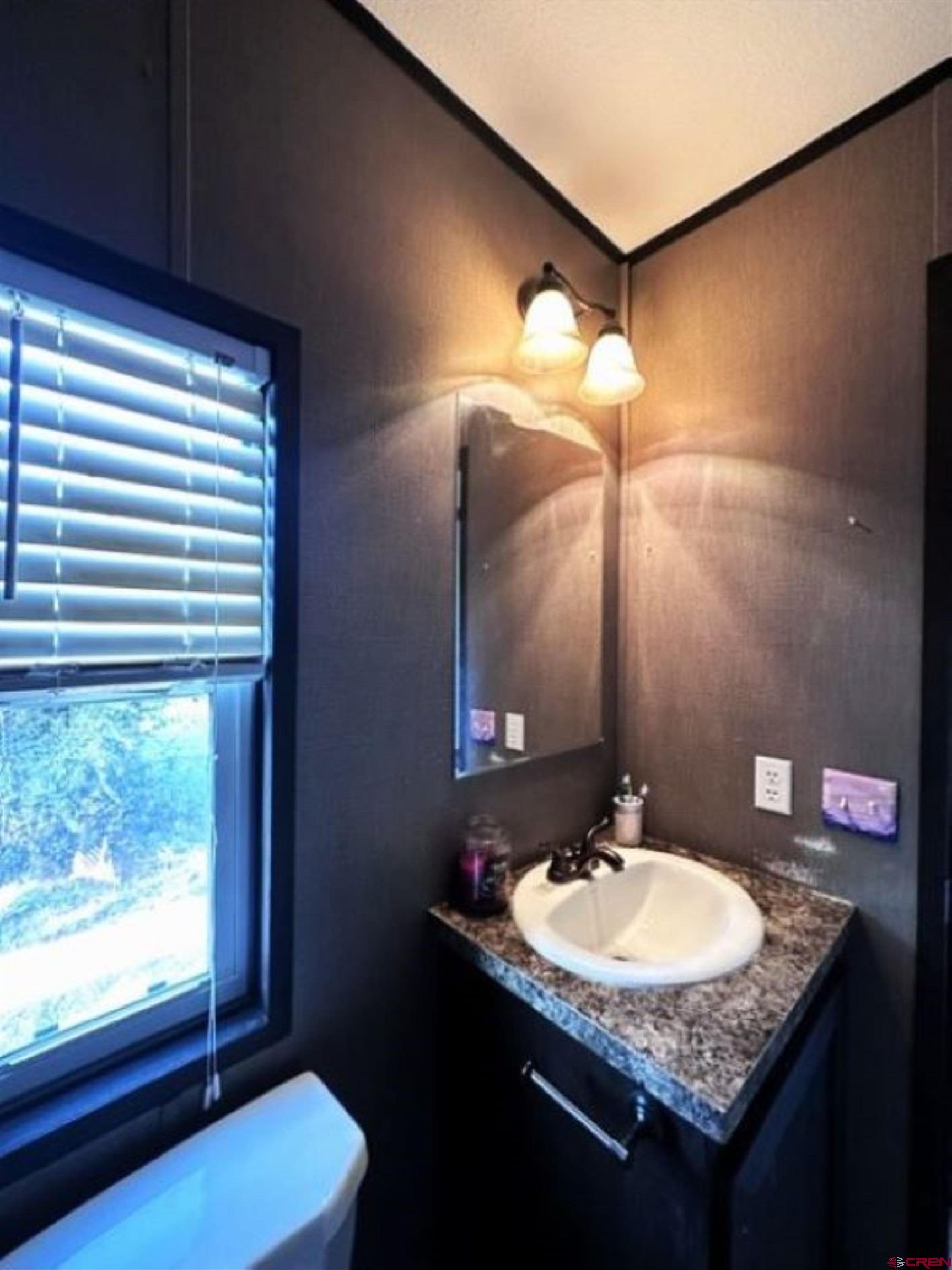 62880 Lasalle Road, Unit 185 Montrose, CO 81401 - Photo 15 of 19 a bathroom with a granite countertop sink and a mirror