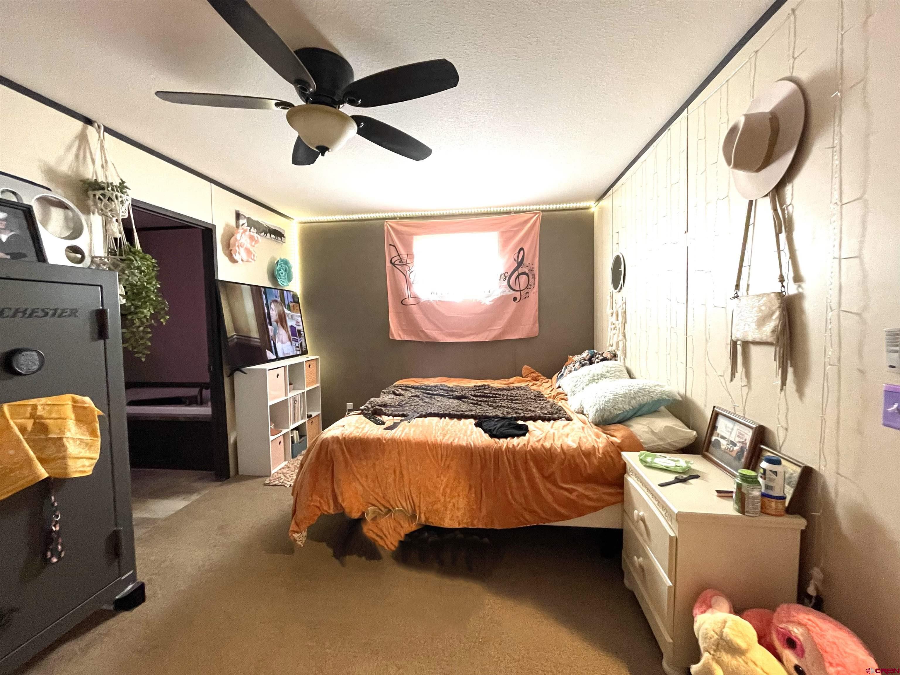 62880 Lasalle Road, Unit 185 Montrose, CO 81401 - Photo 6 of 19 a bedroom with a bed dresser and a flat tv screen
