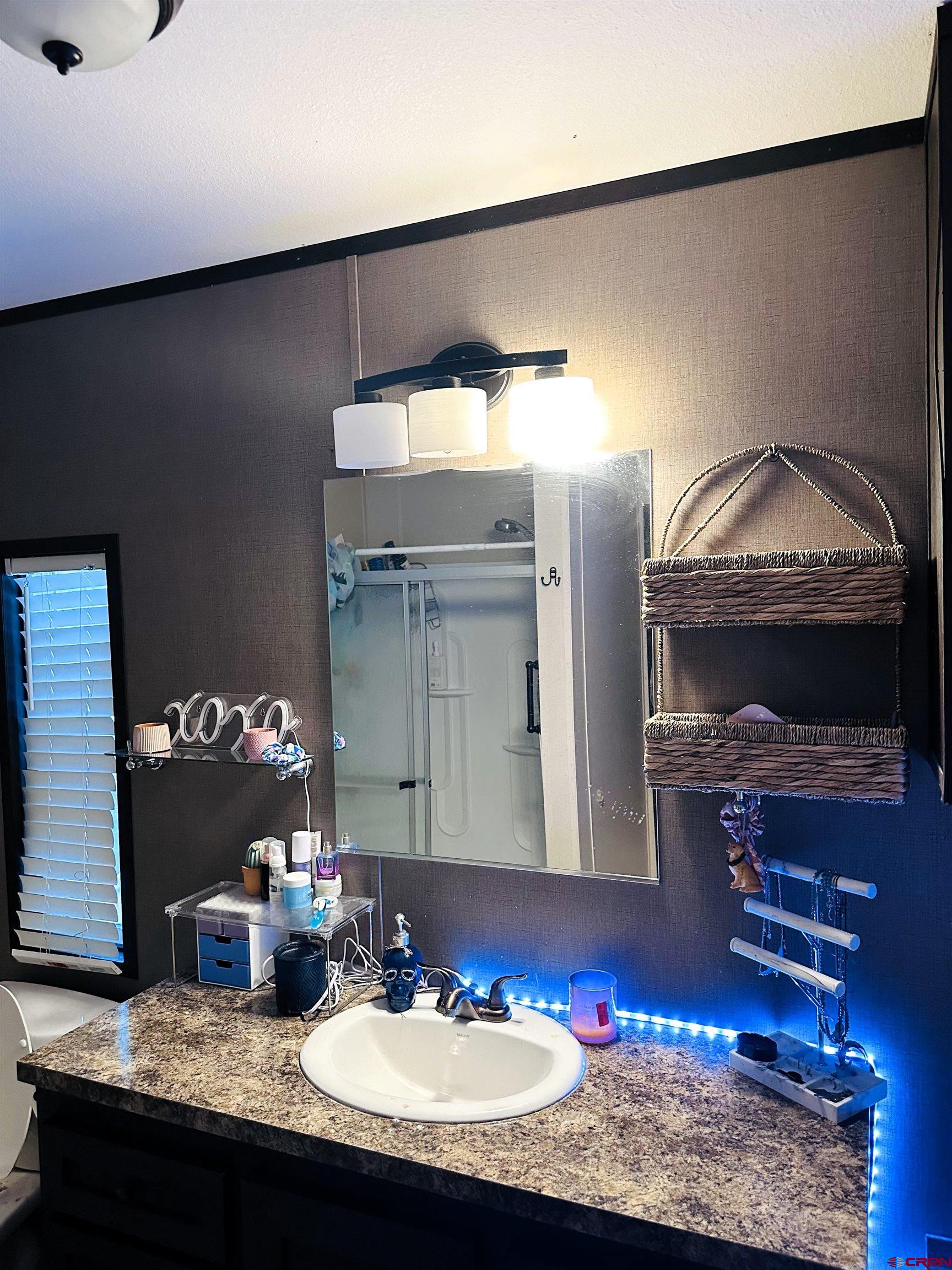 62880 Lasalle Road, Unit 185 Montrose, CO 81401 - Photo 9 of 19 a bathroom with a granite countertop sink and a mirror
