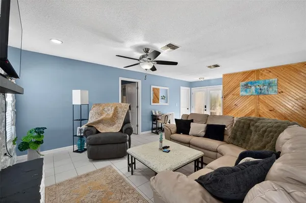 a living room with furniture kitchen view and a chandelier