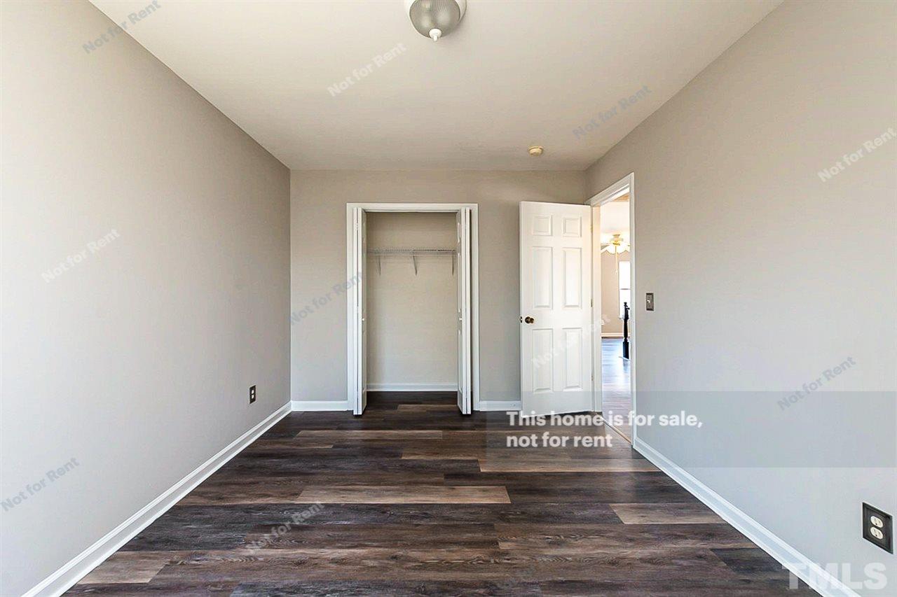 5304 Neuse Forest Road Raleigh, NC 27616 - Photo 22 of 26 a view of a hallway with wooden floor and a bathroom