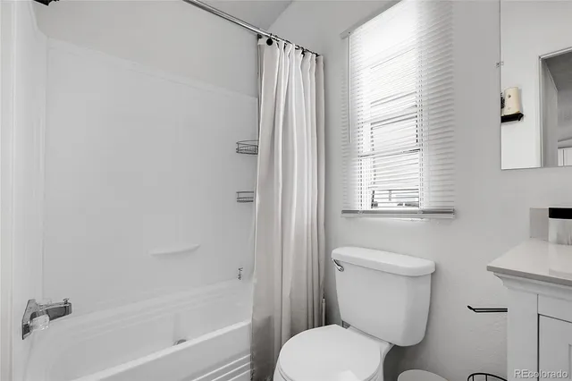 a white toilet sitting next to a bath tub